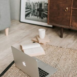 Laptop and journal on a relaxed living room floor, exploring free psychology and wellbeing resources online