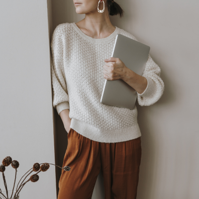 Woman holding a laptop representing personal development and professional wellbeing