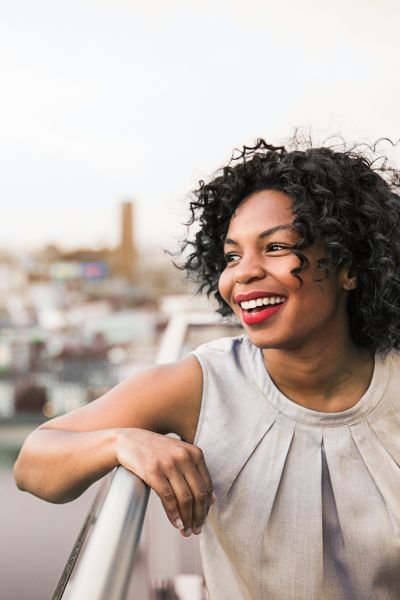 Woman smiling confidently, representing momentum in coaching