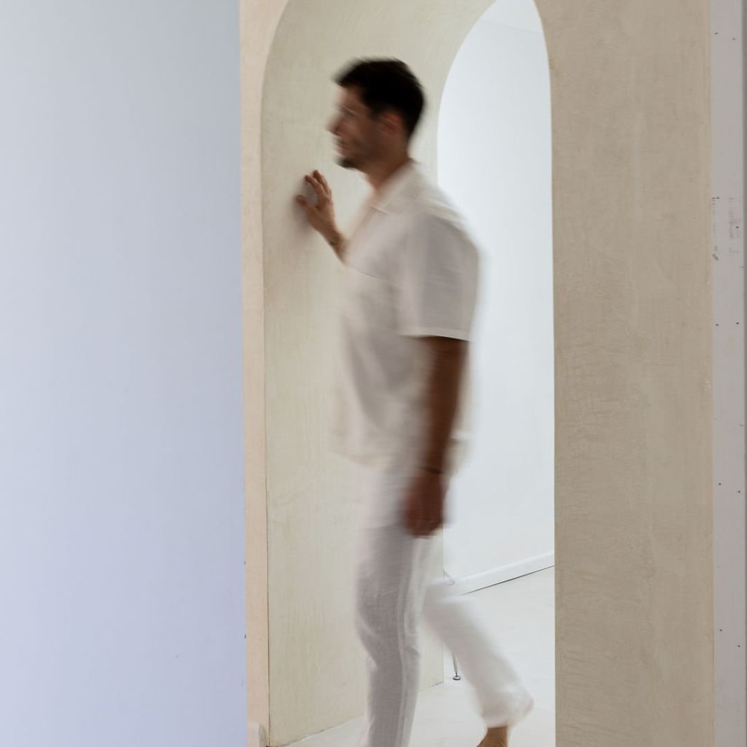 A man walking purposefully through a light-filled room, slightly blurred, representing the experience of anxiety and learning to move forward with confidence rather than avoidance