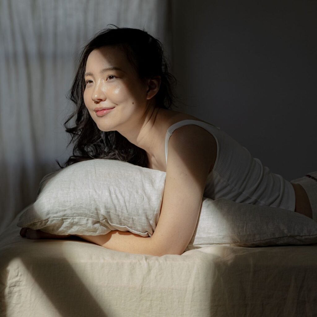 image of a woman resting peacefully on a pillow in warm light having experienced benefits of hypnosis for insomnia