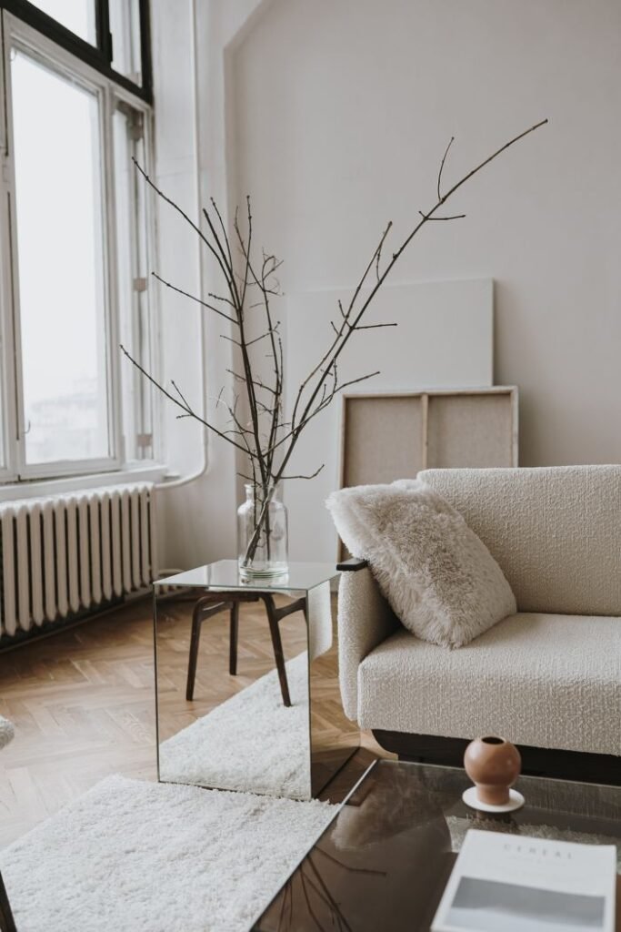 A bright, minimalist room with tall windows and a single dark branch in a vase, reflecting the calm and clarity that integrative therapy in Warwickshire can help you find