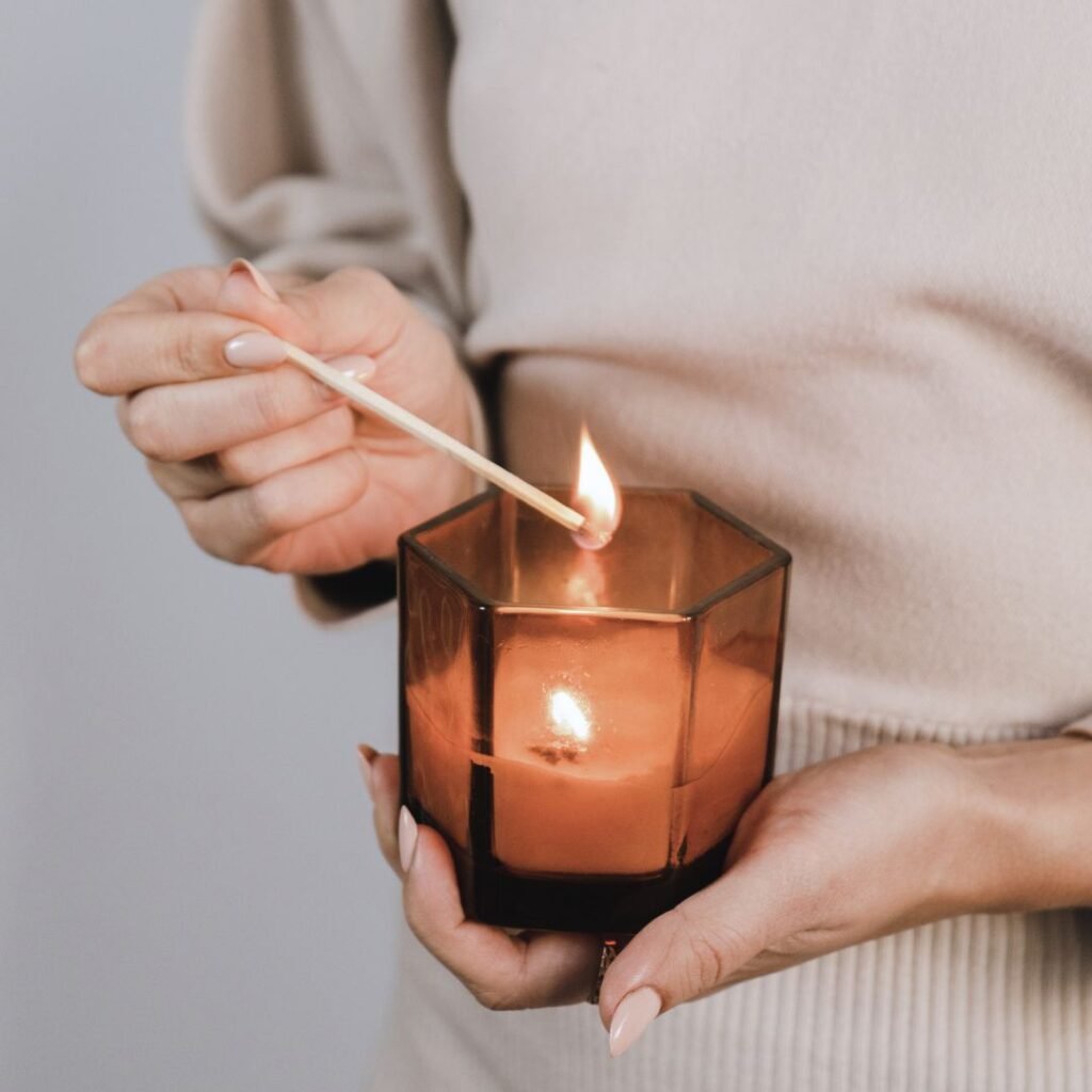 A single lit candle in soft focus, representing the calm and steadiness that comes from learning to manage stress differently
