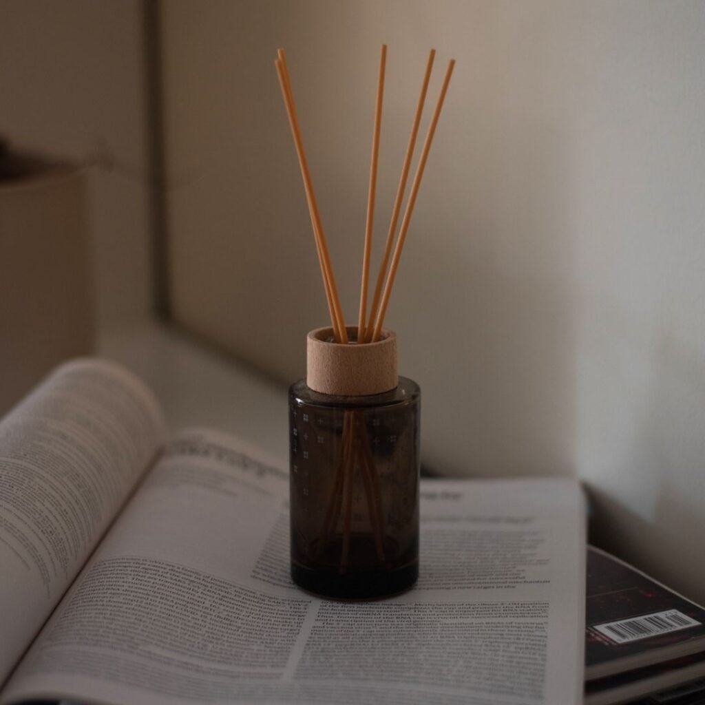 A reed diffuser resting on a book, evoking a quiet moment of calm at home