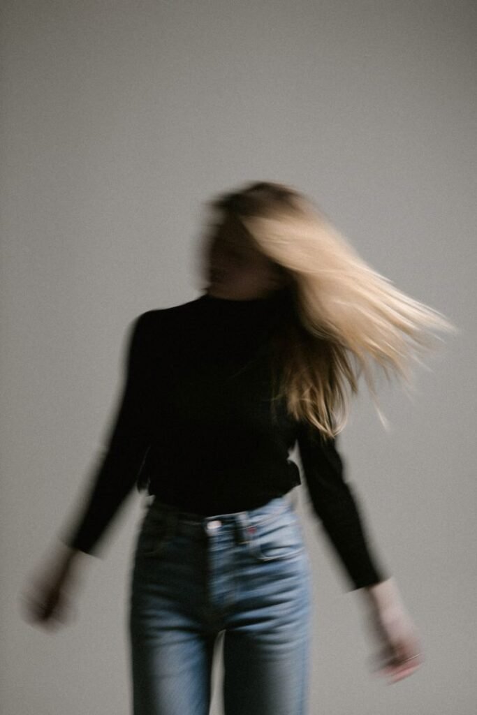 A woman with dark hair captured in motion, conveying the relentless pace of living with persistent anxiety