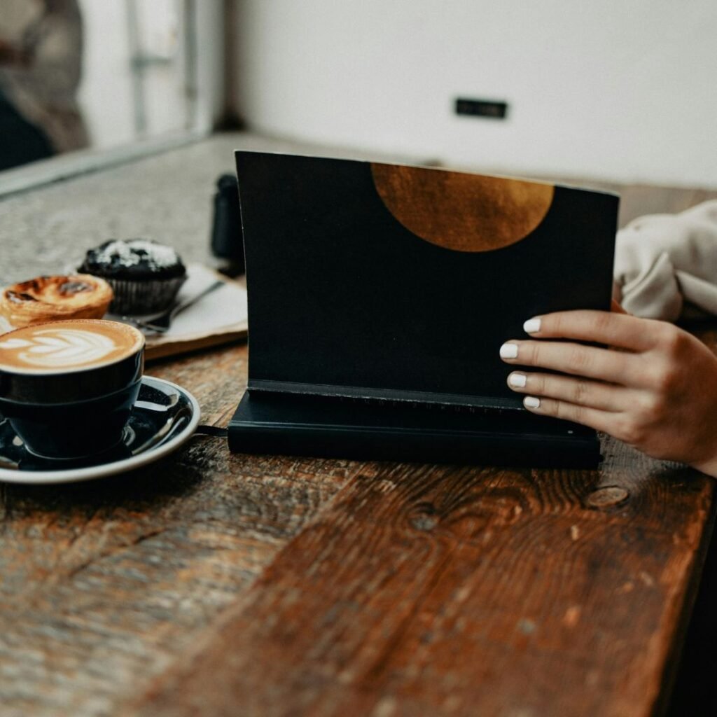 Woman opening notebook at a café table representing focus and clarity