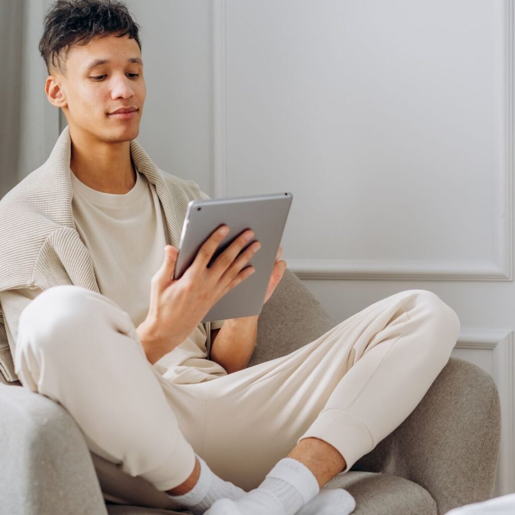 Man sitting calmly with a tablet, representing confidence and personal growth