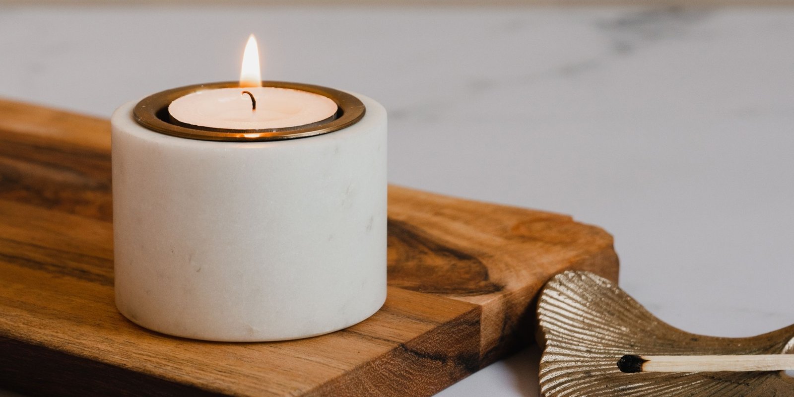 Lit candle on wooden surface representing mindfulness practice