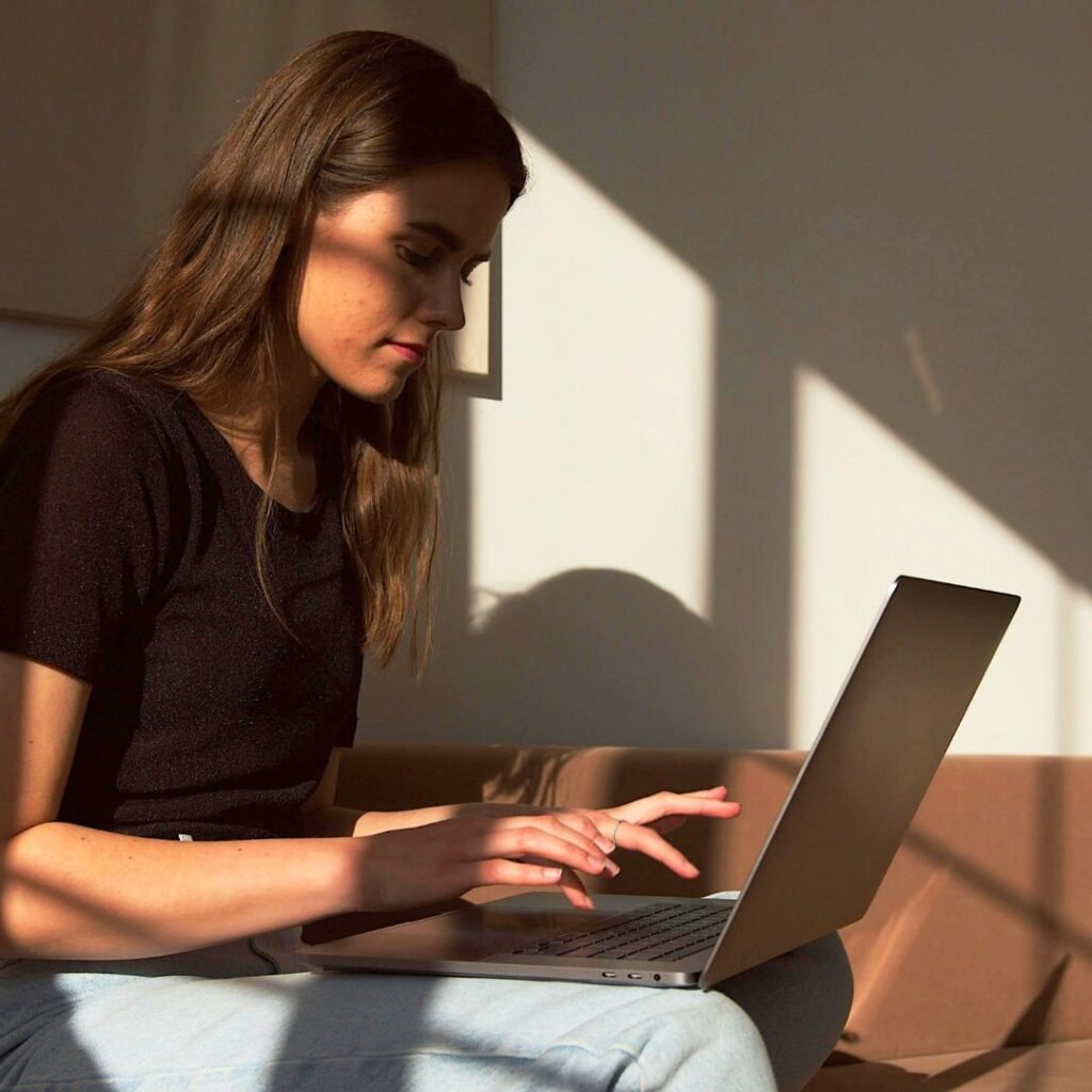 Woman working at a laptop, representing an online therapy consultation with Lucy Mundy, available to clients across the UK