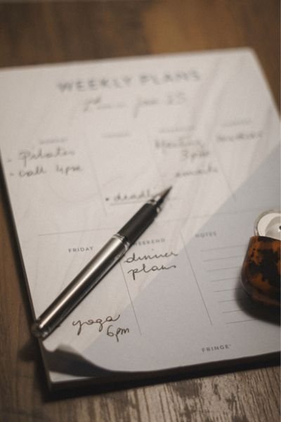 Open weekly planner with handwritten notes, representing the constant mental load of chronic stress